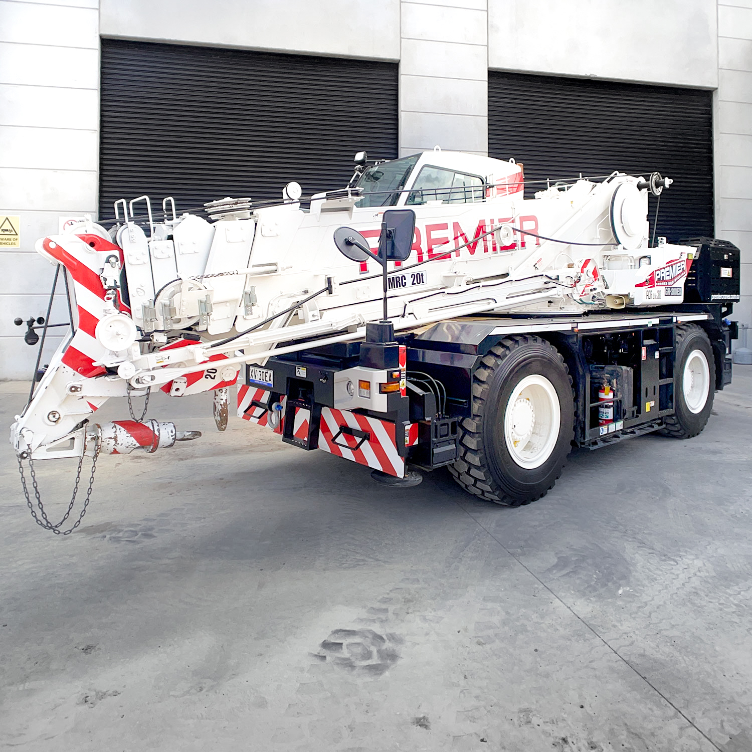 A large crane is parked in front of a building